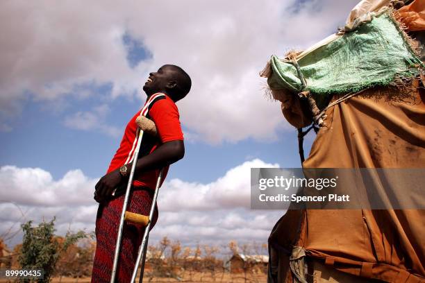 Osman Omar Amer stands on cruthches outside the hut where he lives August 21, 2009 in Dadaab, the world�s biggest refugee complex in Dadaab, Kenya....