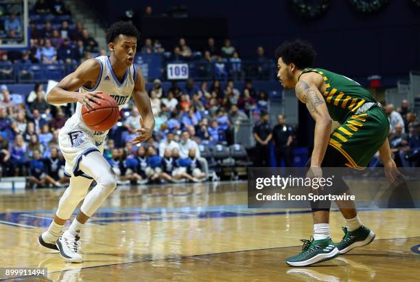 Rhode Island Rams guard Jeff Dowtin defended by George Mason Patriots guard Otis Livingston II during a college basketball game between George Mason...