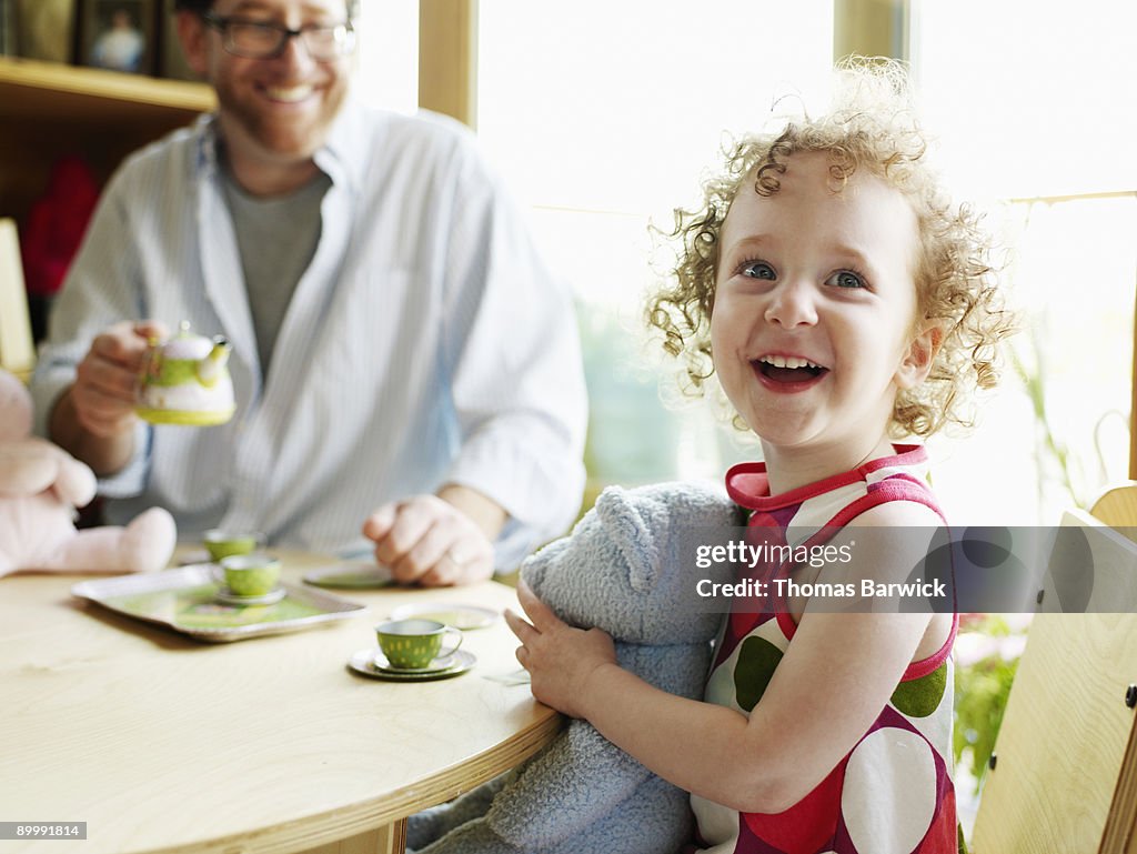 Father and young daughter having tea party