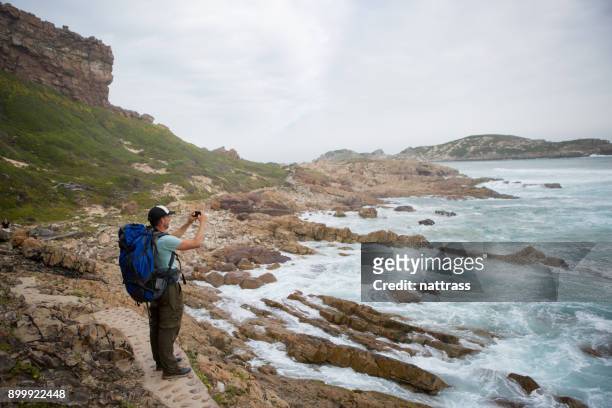 männliche wanderer steht und nimmt ein foto der ansicht - confidence male landscape stock-fotos und bilder