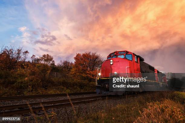 atardecer tren de carga - locomotive fotografías e imágenes de stock