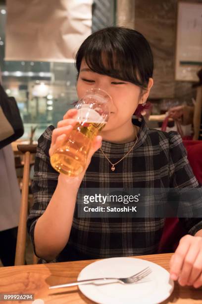 jeune femme buvant de la bière au restaurant - kyobashi tokyo photos et images de collection