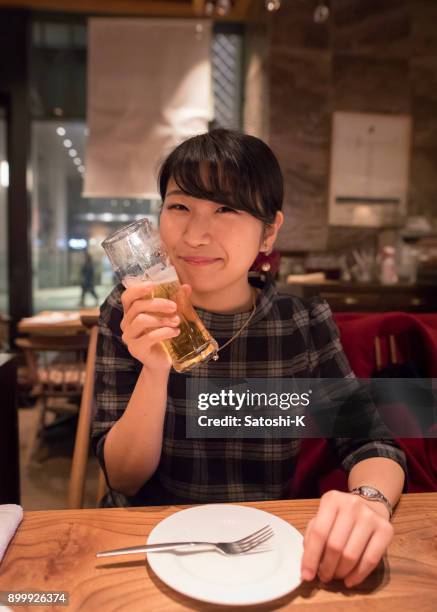 jeune femme buvant de la bière au restaurant - kyobashi tokyo photos et images de collection