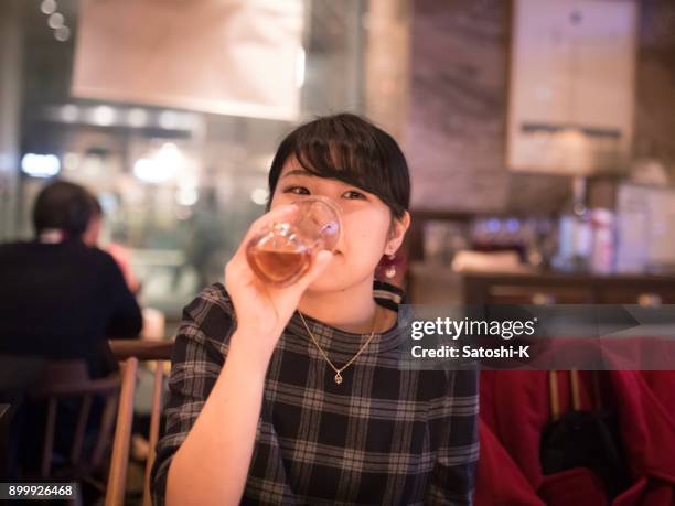 jeune femme buvant de la bière au restaurant - kyobashi tokyo photos et images de collection