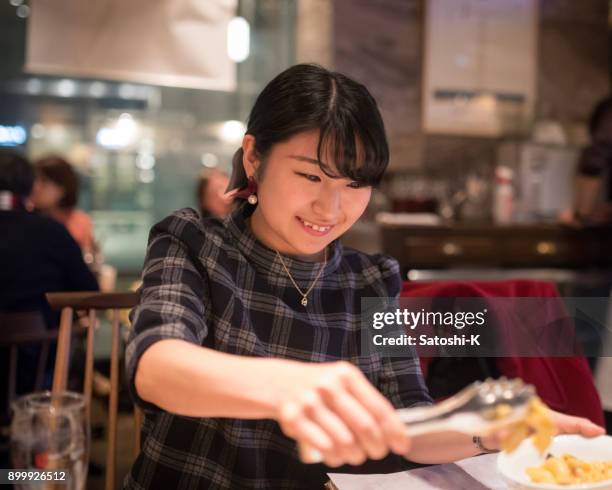 jeune femme en train de dîner au restaurant - kyobashi tokyo photos et images de collection