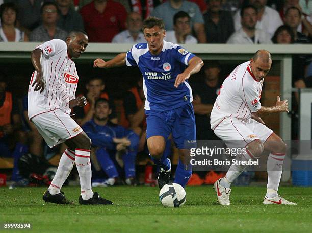 Marcel Schied of Rostock battles for the ball with Younga Mouhani and Marco Gebhardt of Berlin during the Second Bundesliga match between 1. FC Union...