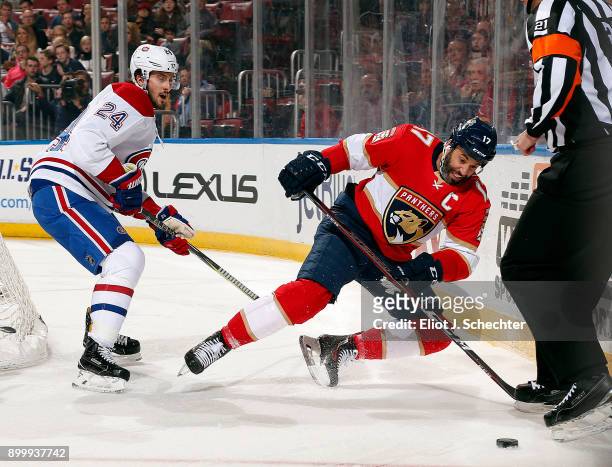 Derek MacKenzie of the Florida Panthers digs the puck out from the boards against Phillip Danault of the Montreal Canadiens at the BB&T Center on...