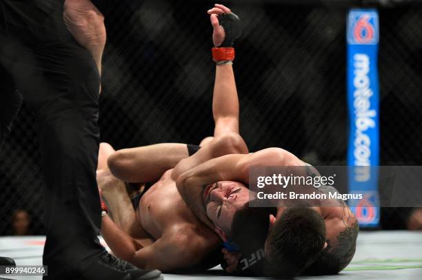 Matheus Nicolau of Brazil attempts to secure a choke submission against Louis Smolka in their flyweight bout during the UFC 219 event inside T-Mobile...