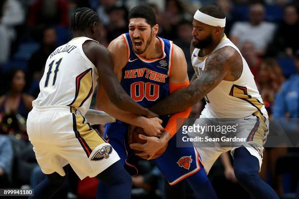 Jrue Holiday of the New Orleans Pelicans Enes Kanter of the New York Knicks and DeMarcus Cousins of the New Orleans Pelicans go for a jumb ball...