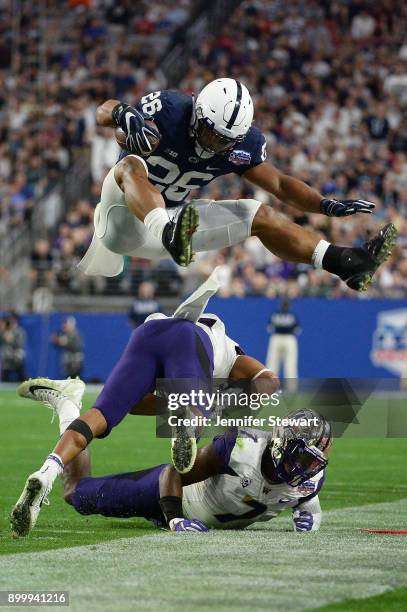 Running back Saquon Barkley of the Penn State Nittany Lions leaps over defensive back Austin Joyner and linebacker Keishawn Bierria of the Washington...