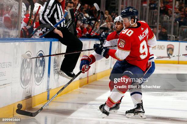 Phillip Danault of the Montreal Canadiens digs the puck out from the boards against Jared McCann of the Florida Panthers at the BB&T Center on...