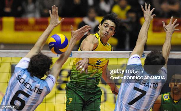 Brazil's Giba spikes the ball against Argentina`s Gustavo Scholtis and Gustavo Porporatto during their South American Final men's volleyball match in...
