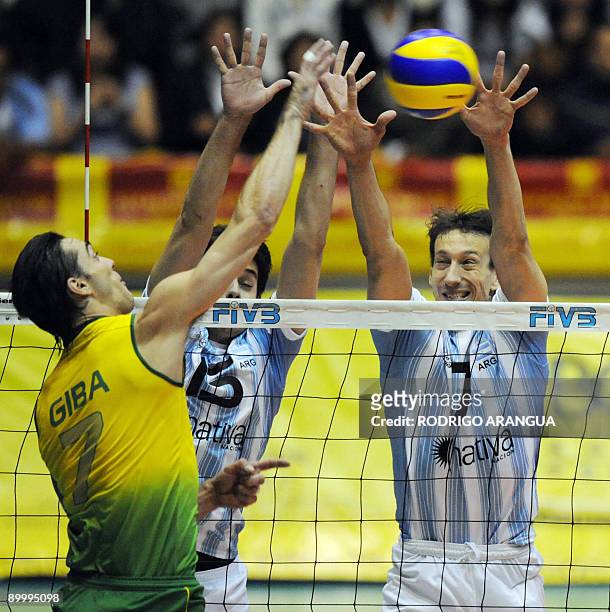 Brazil's Giba spikes the ball against Argentina`s Federico Pereyra and Gustavo Porporatto during their South American Final men's volleyball match in...
