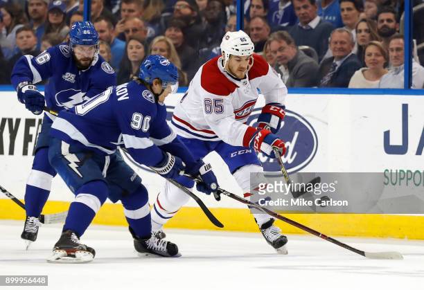 Andrew Shaw of the Montreal Canadiens and Vladislav Namestnikov of the Tampa Bay Lightning look for a loose puck during the first period at Amalie...