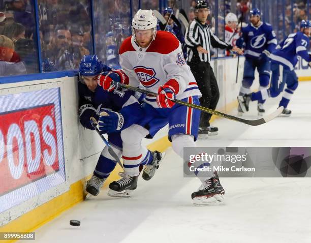 Joe Morrow of the Montreal Canadiens checks Cedric Paquette of the Tampa Bay Lightning during the second period at Amalie Arena on December 28, 2017...