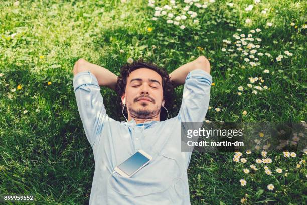 hombre la siesta en la hierba - meditation outdoors fotografías e imágenes de stock