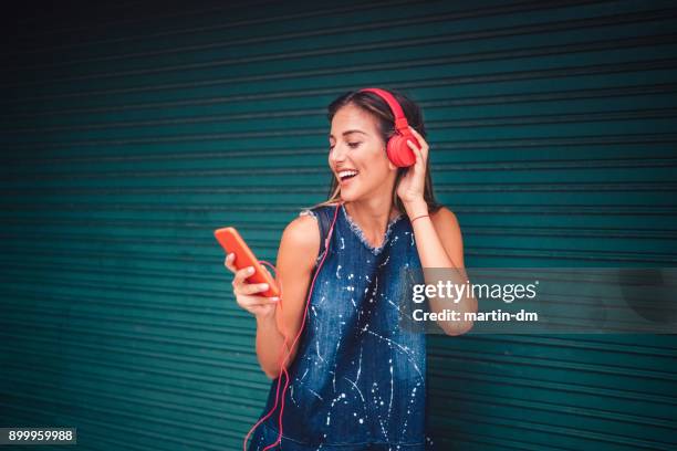 girl enjoying a mobile app for online music - student coloured background stock pictures, royalty-free photos & images