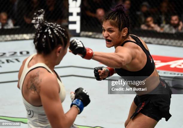 Cynthia Calvillo punches Carla Esparza in their women's strawweight bout during the UFC 219 event inside T-Mobile Arena on December 30, 2017 in Las...