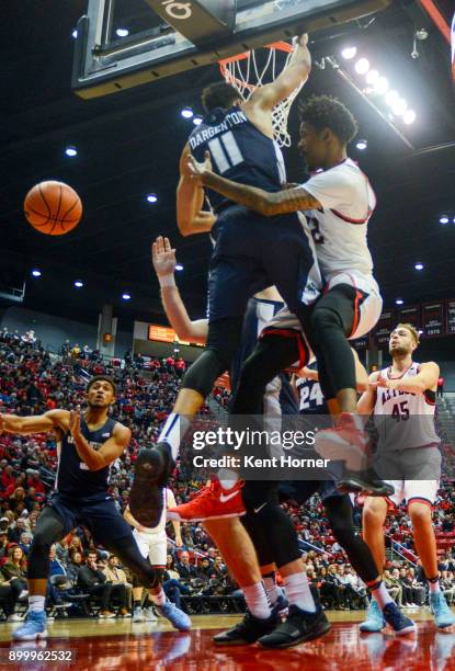 Jeremy Hemsley of San Diego State Aztecs passes the ball in the first half around Alex Dargenton of the Utah State Aggies at Viejas Arena on December...