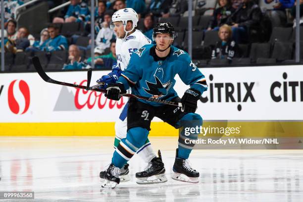 Jannik Hansen of the San Jose Sharks skates against Brendan Gaunce of the Vancouver Canucks at SAP Center on December 21, 2017 in San Jose,...