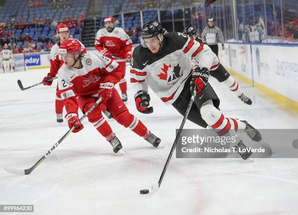 Michael McLeod of Canada skates the puck past Oliver Larsen of Denmark during the third period of play in the IIHF World Junior Championships at the...