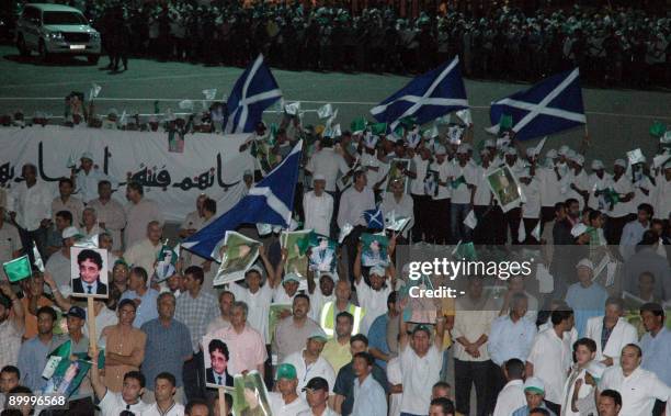 Hundreds of flag-waving well-wishers wait at the tarmac of Metiga airport in Tripoli to welcome freed Lockerbie bomber Abdelbaset Ali Mohmet...