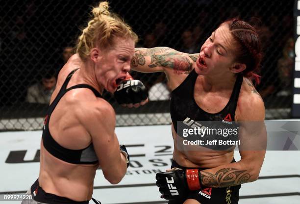 Cris Cyborg of Brazil punches Holly Holm in their women's featherweight bout during the UFC 219 event inside T-Mobile Arena on December 30, 2017 in...