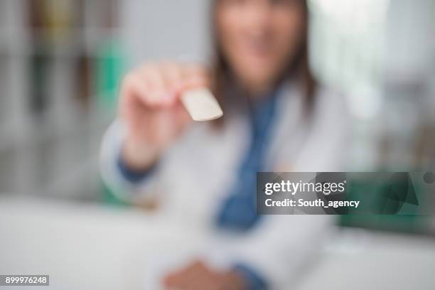 vrouwelijke arts met tong depressor - mensentong stockfoto's en -beelden