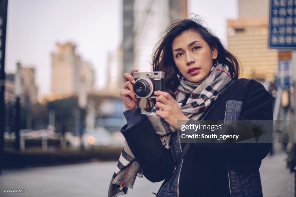 Beautiful woman with camera on the street