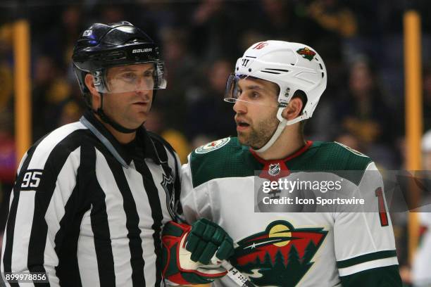 Linesman Jonny Murray separates Minnesota Wild left wing Jason Zucker from a scrum during the NHL game between the Nashville Predators and the...