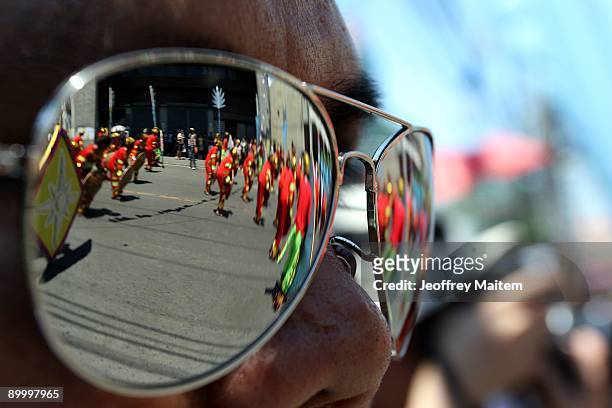 Filipino dancers, seen in the reflection of a local tourist sunglass, perform in the annual Kadayawan Festival on August 22, 2009 in Davao,...