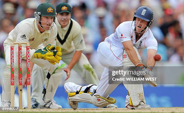 England batsman Andrew Strauss is hit on the arm while sweeping as Australian players Brad Haddin and Marcus North look on during England's 2nd...