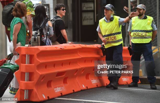 Police give directions to visitors before the start of New Year's Eve celebrations in the central business district of Sydney on December 31, 2017....