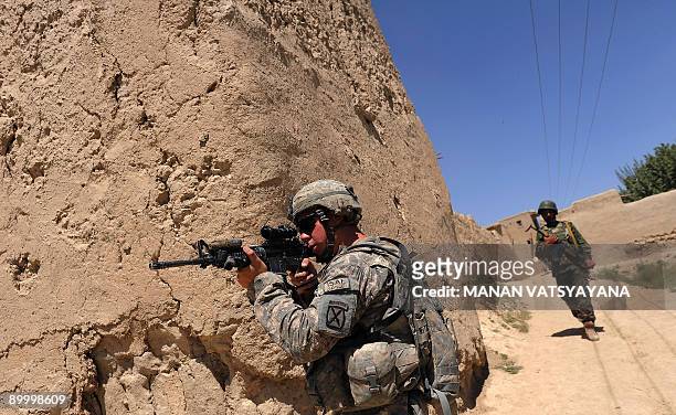 Private First Class Andrew Busch from the 1st Platoon Alpha 3-71 Cavalry secures an area during a mission at a village in the Baraki Barak district...