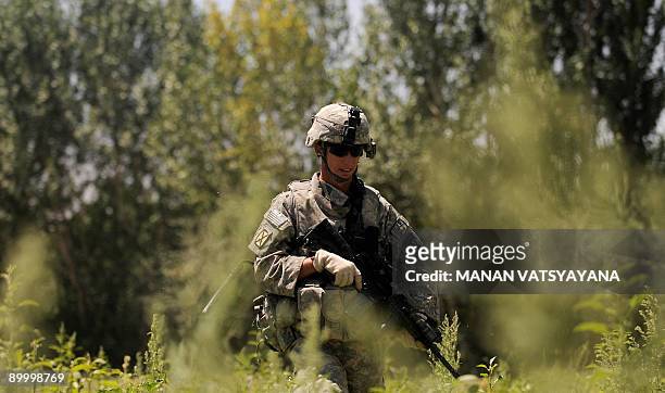 Soldier from the 1st Platoon Alpha 3-71 Cavalry walks through a field during a mission at a village in the Baraki Barak district of Logar Province on...