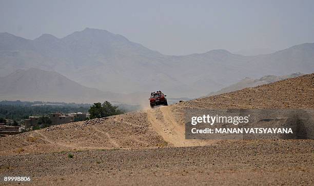 An Afghan family rides in a car across the hill at a village in the Baraki Barak district of Logar Province on August 22, 2009. US President Barack...