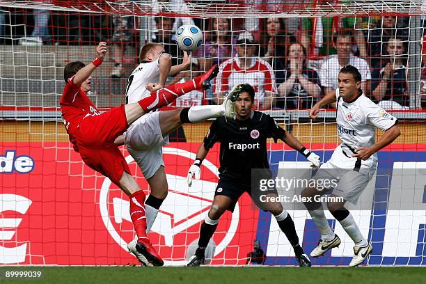 Milivoje Novakovic of Koeln tries to score a goal against Patrick Ochs, goalkeeper Oka Nikolov and Aleksandar Vasoski of Frankfurt during the...