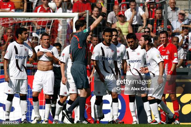 Referee Manuel Graefe shows a yellow card to Ioannis Amanatidis of Frankfurt during the Bundesliga match between 1. FC Koeln and Eintracht Frankfurt...