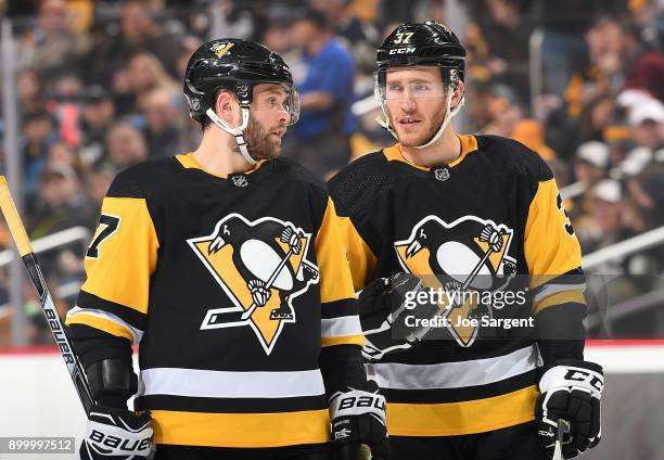 Bryan Rust talks with Carter Rowney of the Pittsburgh Penguins during the game against the Columbus Blue Jackets at PPG Paints Arena on December 27,...