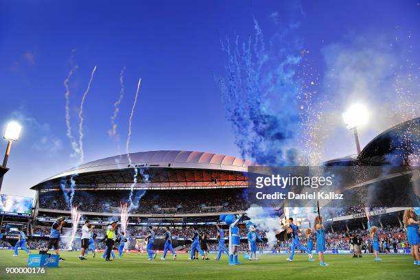Strikers players run onto the field to field during the Big Bash League match between the Adelaide Strikers and the Brisbane Heat at Adelaide Oval on...