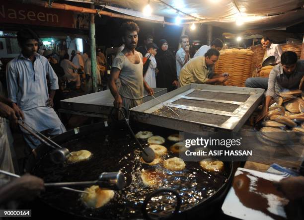 Pakistani bakers prepare of "Khajla," sweet dish which is widely popular during the holy month of Ramadan, at a shop in Karachi on August 22, 2009....