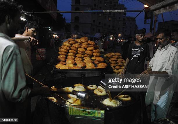 Pakistani bakers prepare "Khajla," sweet dish which is widely popular during the holy month of Ramadan, at a shop in Karachi on August 22, 2009....