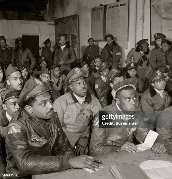 Tuskegee airmen attending a briefing. First row: 1. Hiram E. Mann, Cleveland, OH, Class 44-F; 2. Unidentified; 3. Newman C. Golden, Cincinnati, OH,...