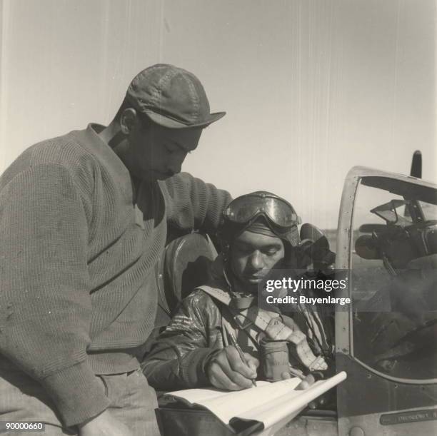 Pilot from the 332nd Fighter Group signing the Form One Book, indicating any discrepancies of aircraft, prior to take off