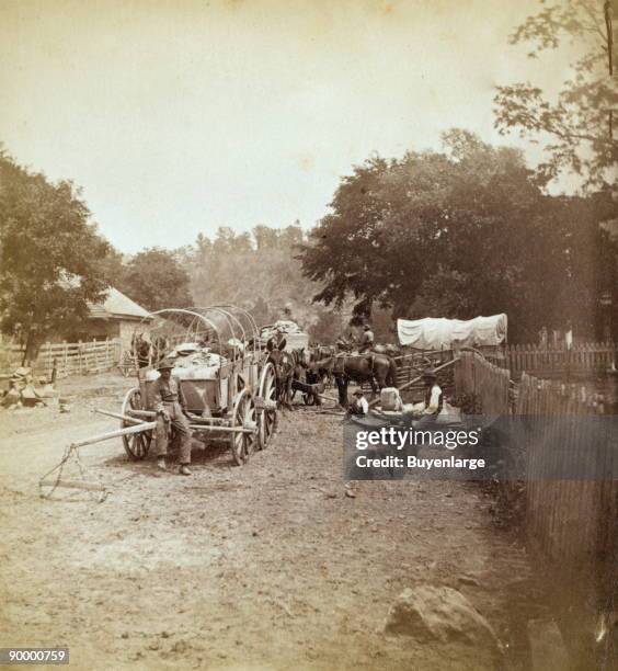 African Americans resting on roadside with covered wagons, at Caldwell's near the Greenbrier Bridge in West Virginia.