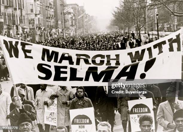 Marchers carrying banner lead way as 15,000 parade in Harlem; "We march with Selma!"