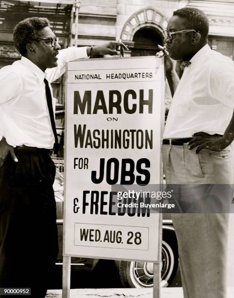 March on Washington Deputy Director Bayard Rustin and Administrative Committee Chairman Cleveland Robinson talk on either side of a sign , at 170 W...