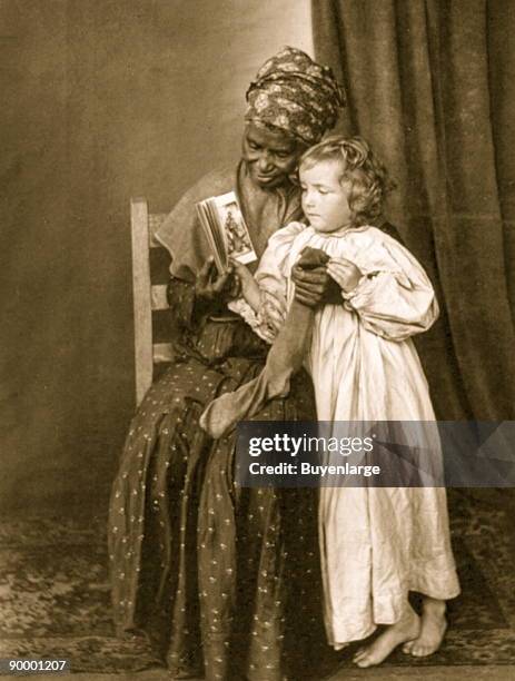 African American woman holding stocking; looking at book with white girl.