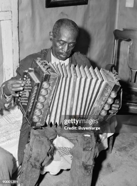 African American Mr. Dyson, aged FSA borrower plays the accordion.