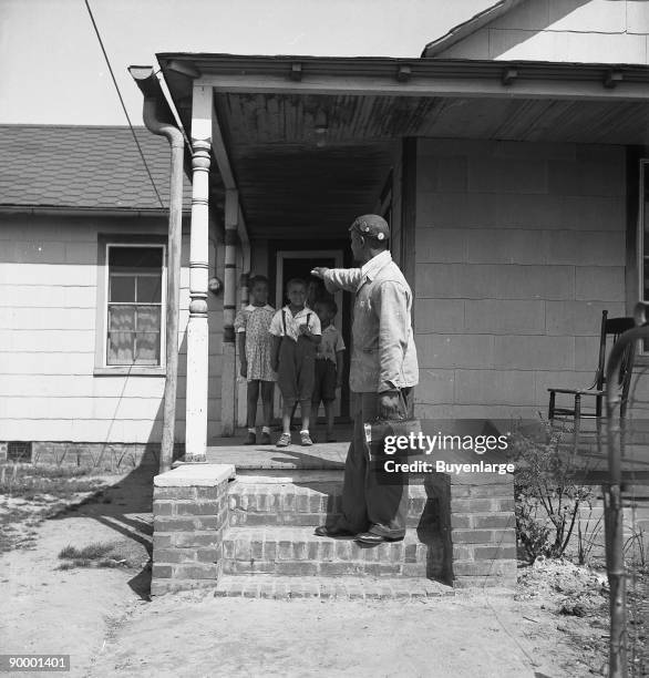 Newport News, Virginia. Negro shipyard worker leaving his rural home for the shipyards with his lunch box